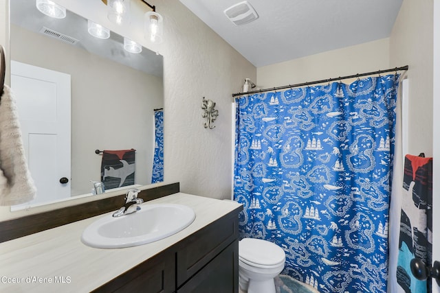 bathroom featuring vanity, a textured ceiling, and toilet