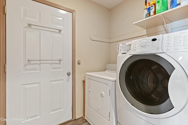 washroom with wood-type flooring and separate washer and dryer