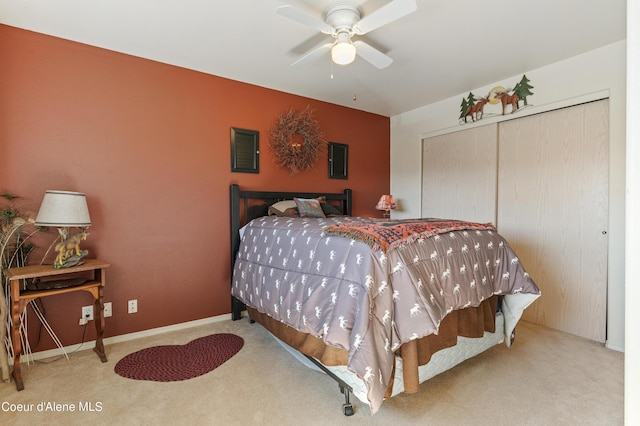 bedroom with light colored carpet, ceiling fan, and a closet