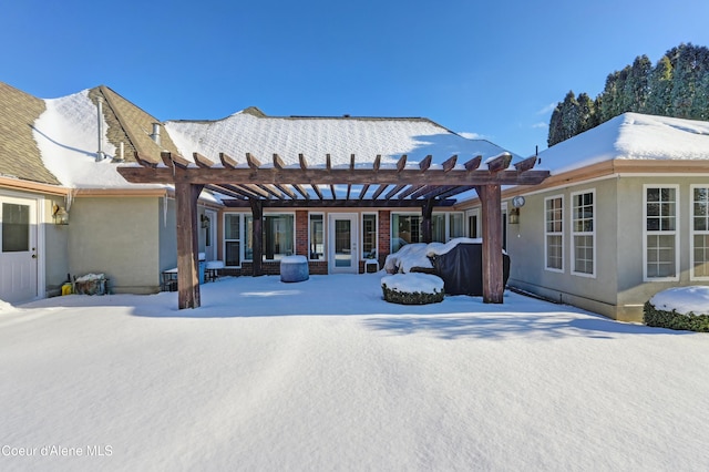 snow covered property with a pergola