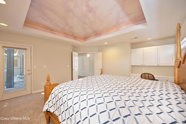 carpeted bedroom featuring access to outside and a raised ceiling