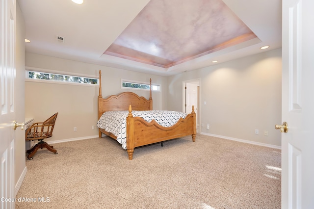 carpeted bedroom with a tray ceiling