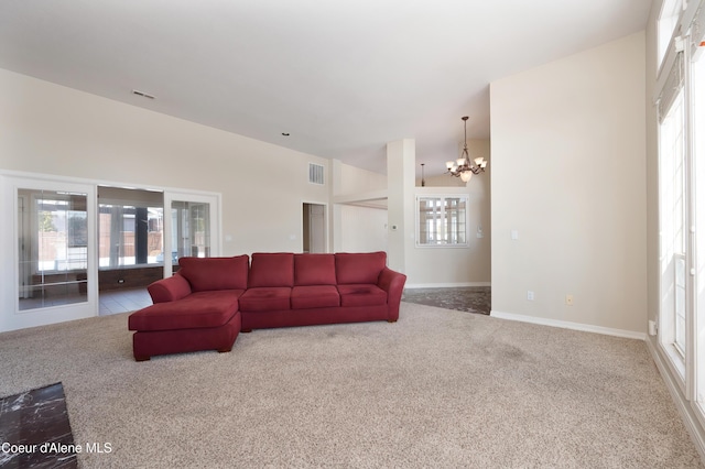 carpeted living room featuring a chandelier