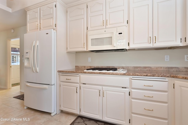 kitchen with light tile patterned floors, white appliances, and white cabinets