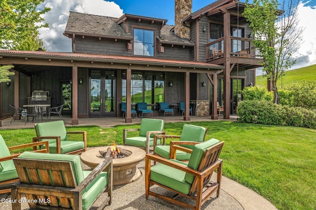 17036 S Citrine Dr, Coeur Dalene, ID 83814 - back of property featuring french doors, a fire pit, a patio area, and a yard