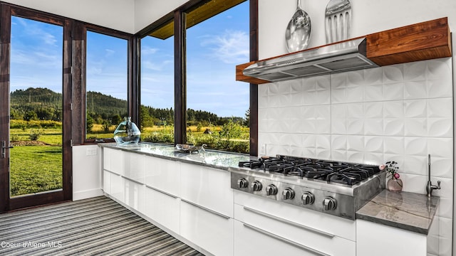 kitchen with white cabinets, dark stone counters, and stainless steel gas stovetop