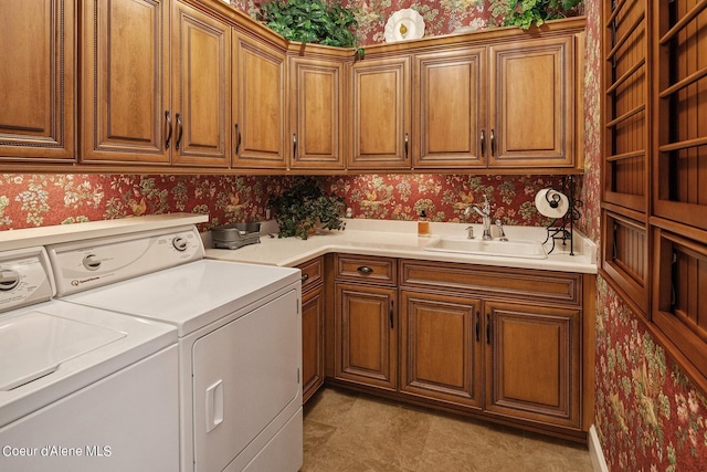 laundry room with cabinets, washing machine and dryer, and sink