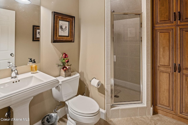 bathroom featuring toilet and a shower with door