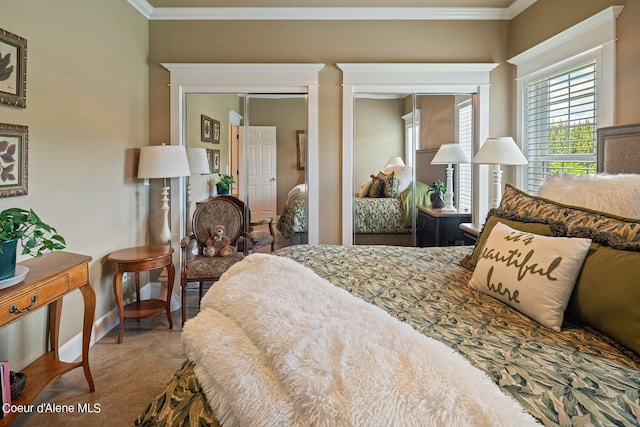 bedroom featuring ornamental molding and two closets