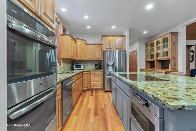 kitchen with light stone counters, sink, gray cabinets, and stainless steel appliances