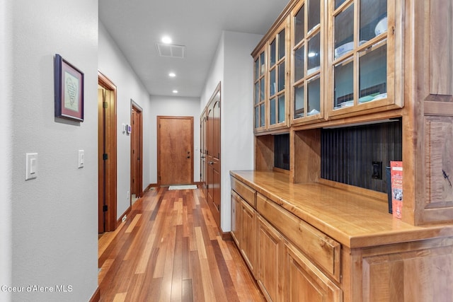 hallway with light hardwood / wood-style floors