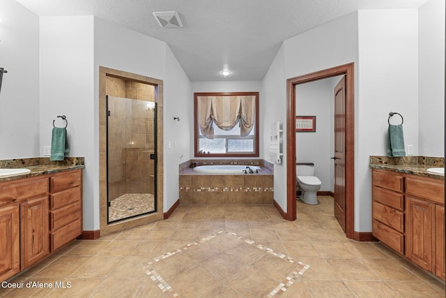 full bathroom featuring tile patterned flooring, vanity, separate shower and tub, toilet, and a textured ceiling