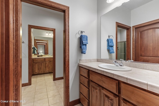 bathroom featuring tile patterned flooring, vanity, and walk in shower