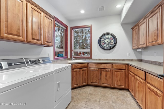 laundry room with cabinets, washer and dryer, sink, and light tile patterned floors