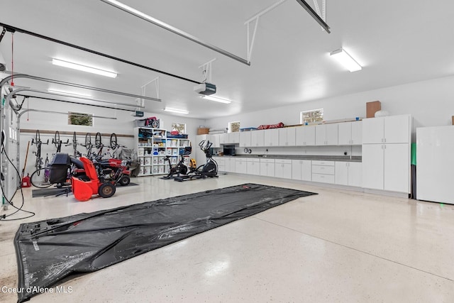 garage with a garage door opener and white fridge