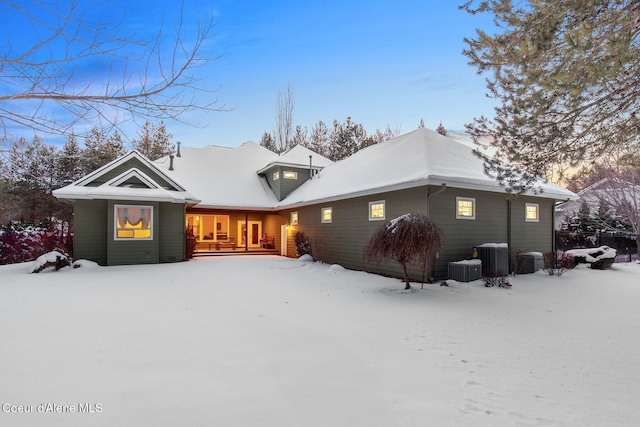 snow covered property with central air condition unit