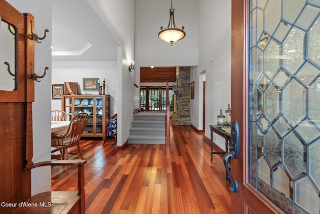 entrance foyer featuring hardwood / wood-style flooring and a towering ceiling