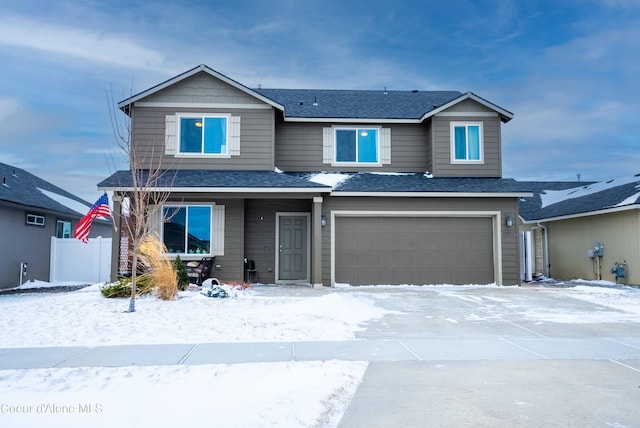 view of front of property with an attached garage, a shingled roof, and fence