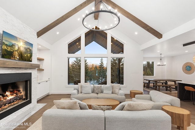 living room with a stone fireplace, high vaulted ceiling, beamed ceiling, a chandelier, and hardwood / wood-style flooring