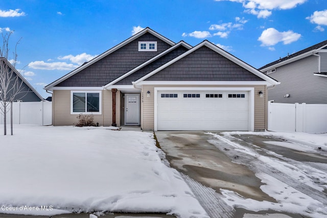 view of front of house with driveway, an attached garage, and fence