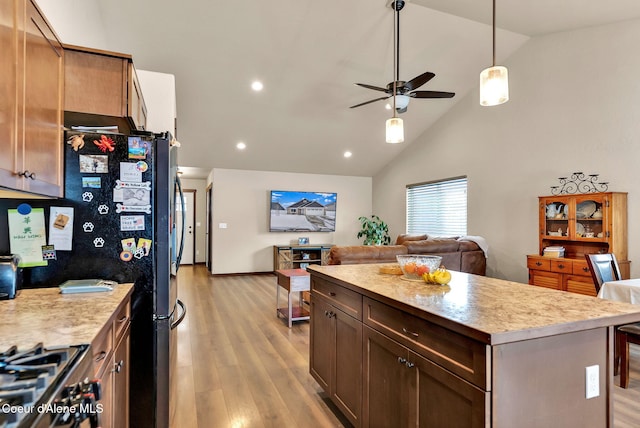 kitchen with open floor plan, light countertops, light wood-type flooring, and a center island