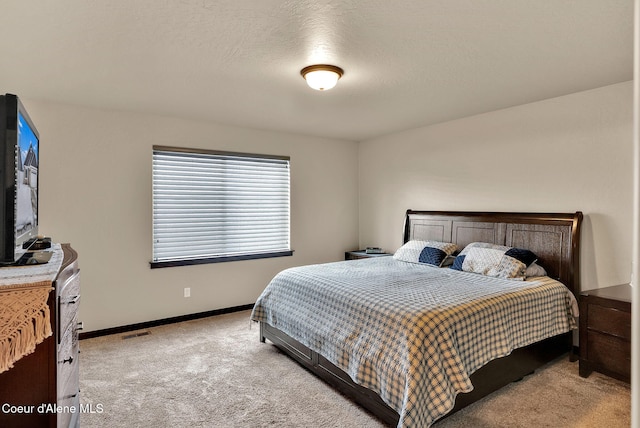 carpeted bedroom featuring visible vents, a textured ceiling, and baseboards