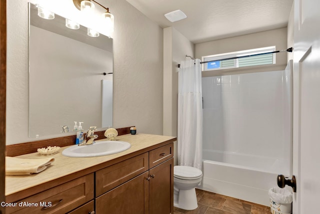 full bathroom with a textured wall, vanity, toilet, and shower / tub combo with curtain