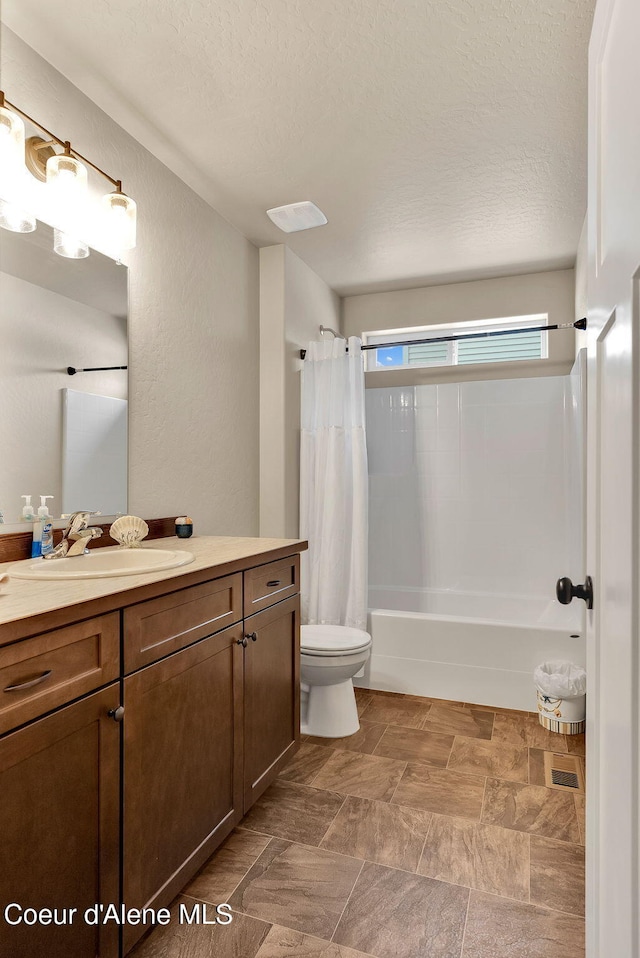 full bathroom with a textured wall, toilet, shower / bath combo, a textured ceiling, and vanity