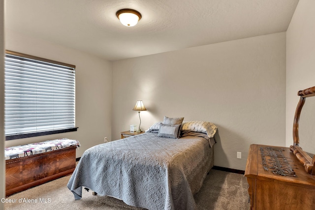 bedroom featuring carpet, baseboards, and a textured ceiling