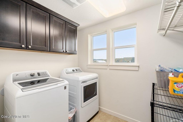 laundry room with cabinets and washer and dryer