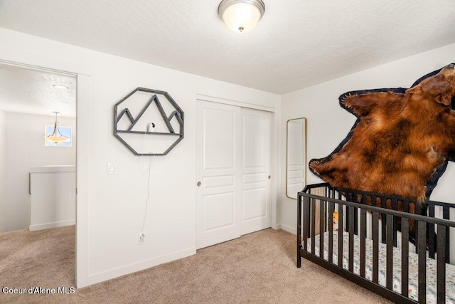 carpeted bedroom featuring a textured ceiling and a closet