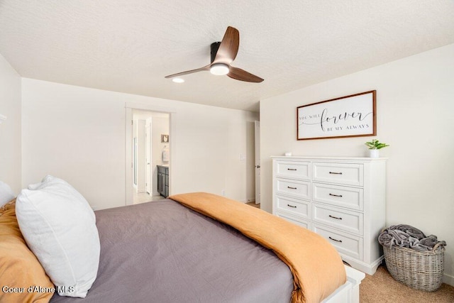 bedroom featuring connected bathroom, light colored carpet, and ceiling fan