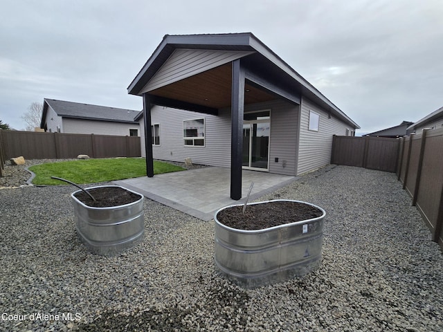 back of property with a patio area and a lawn