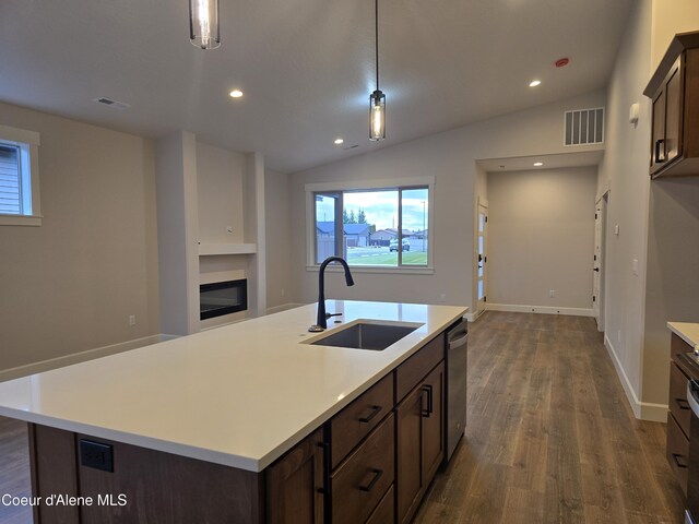 kitchen with pendant lighting, lofted ceiling, and sink