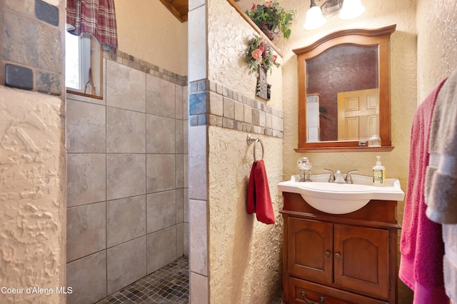 bathroom with vanity and tiled shower