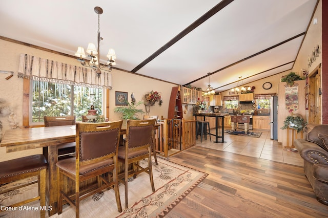 dining area featuring ornamental molding, light hardwood / wood-style floors, vaulted ceiling, and a notable chandelier