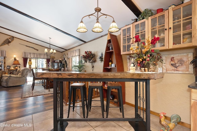 dining room featuring hardwood / wood-style flooring, lofted ceiling, and a notable chandelier