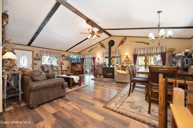 living room with ceiling fan with notable chandelier, lofted ceiling with beams, hardwood / wood-style floors, and a wood stove