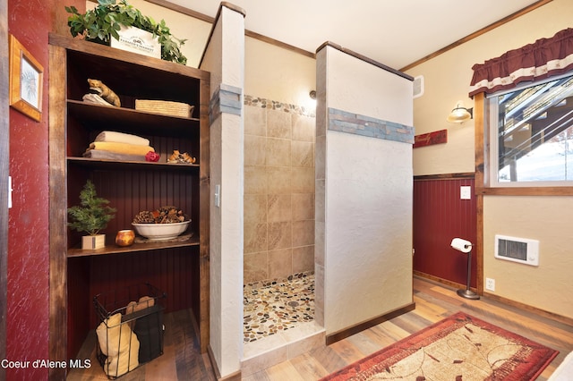 bathroom featuring hardwood / wood-style floors, crown molding, and tiled shower