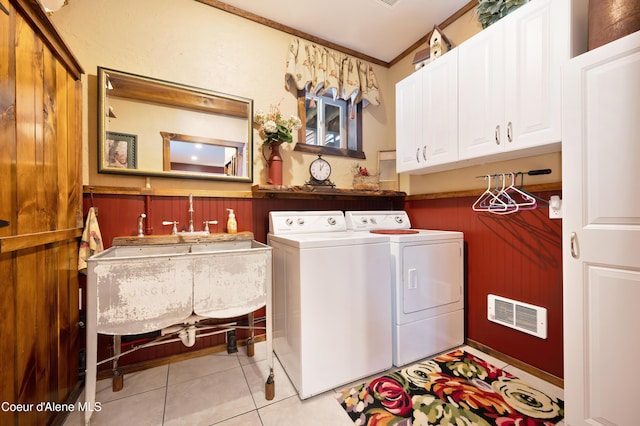 laundry room with light tile patterned floors, sink, washing machine and dryer, cabinets, and ornamental molding