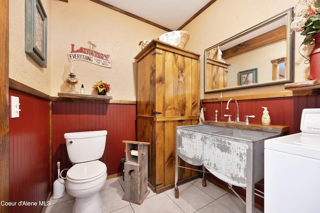 bathroom with wooden walls, washer / clothes dryer, ornamental molding, toilet, and tile patterned floors