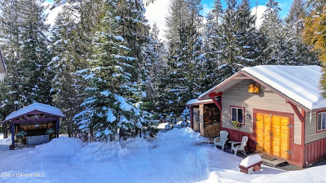 view of snow covered exterior with an outdoor structure