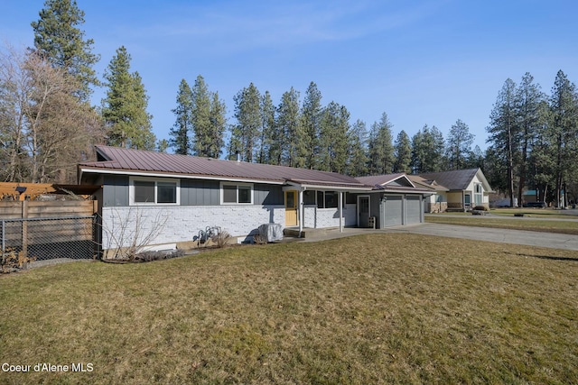 ranch-style house featuring metal roof, a garage, fence, concrete driveway, and a front lawn