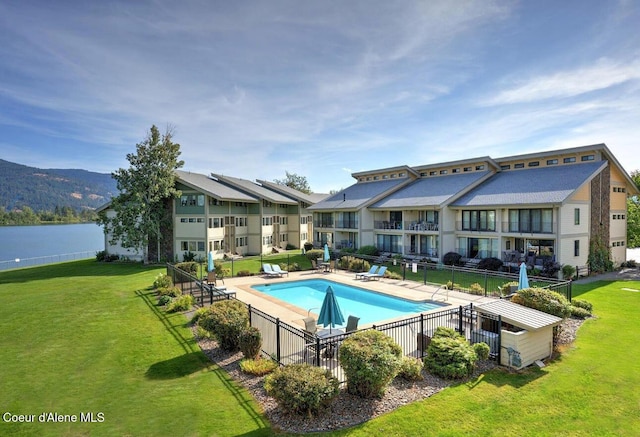 pool featuring fence and a lawn