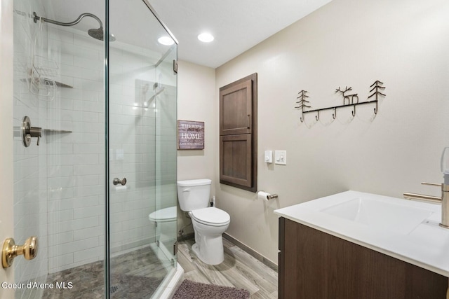 full bathroom featuring a stall shower, vanity, and toilet