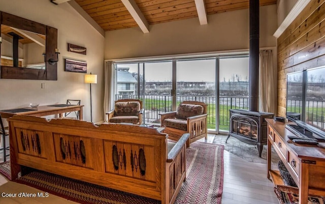 living room with a wood stove, wooden ceiling, lofted ceiling with beams, and wood finished floors