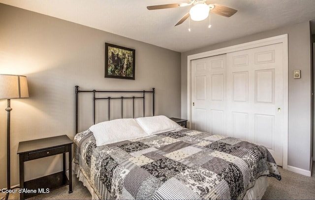 bedroom with a closet, light carpet, ceiling fan, and baseboards