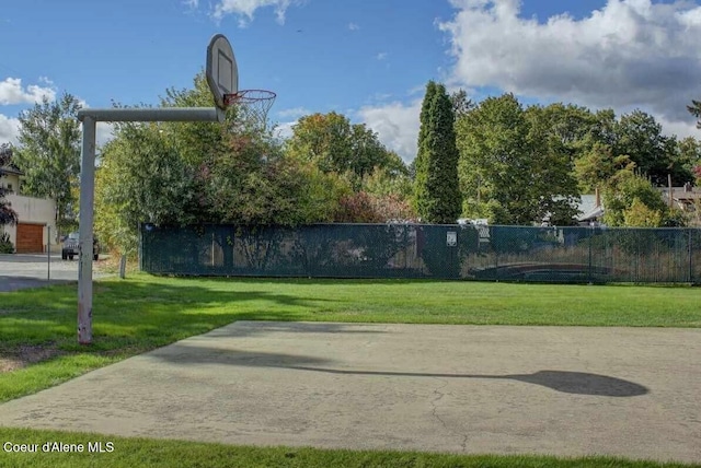 exterior space featuring a yard, community basketball court, and fence