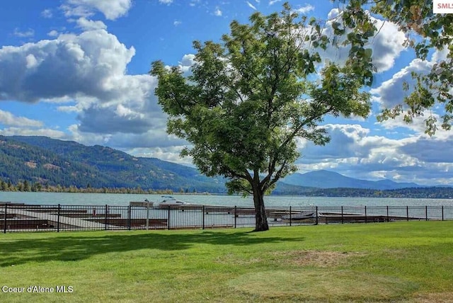 view of yard with fence and a water and mountain view