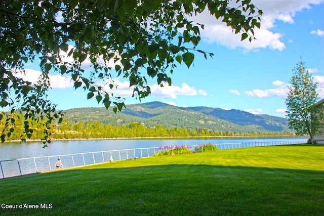 exterior space featuring fence and a water and mountain view